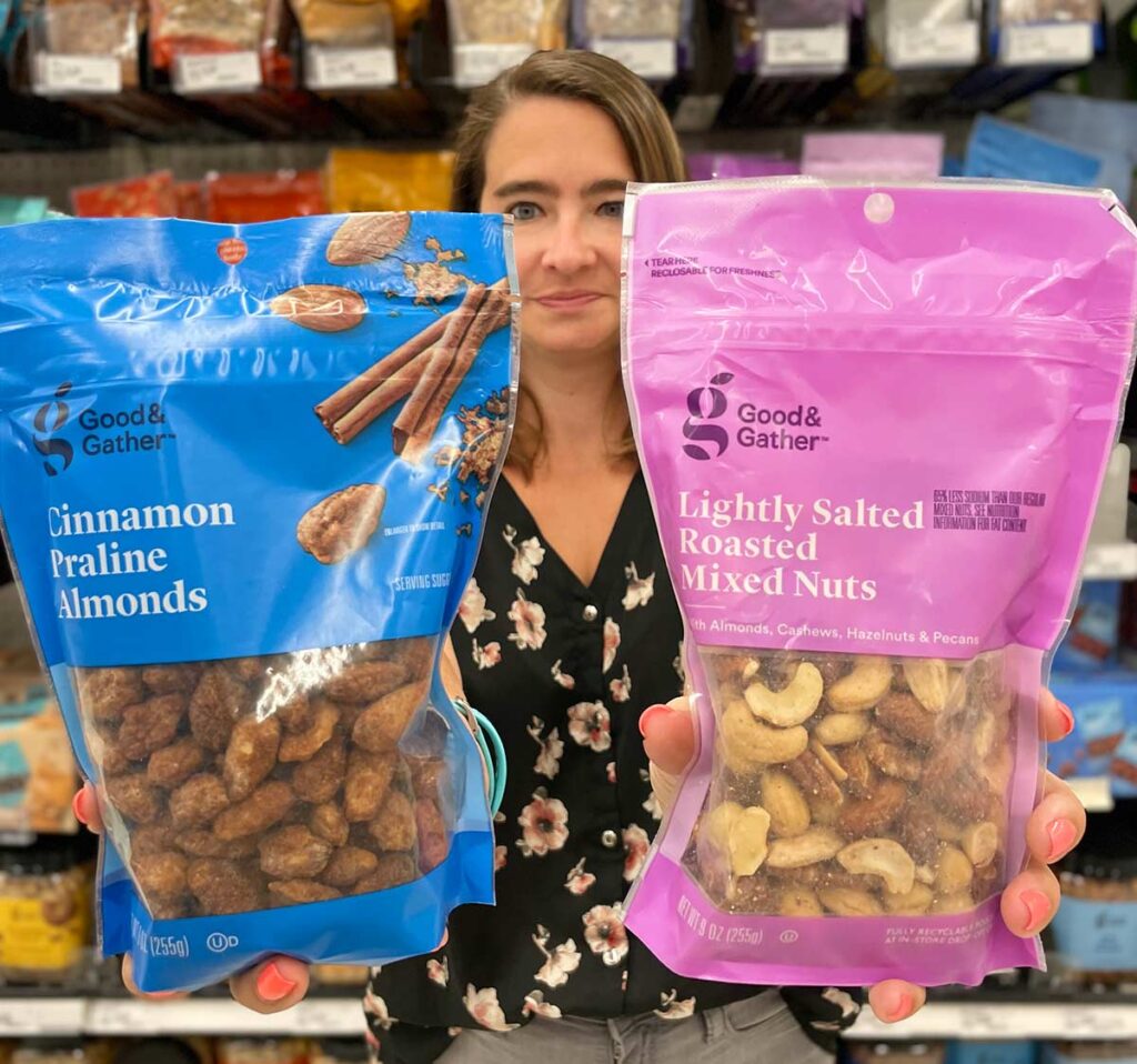 Woman holding flexible stand-up product pouches in a grocery store.